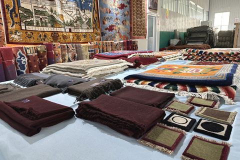 圖為該公司創新生產的牛羊絨圍巾、披肩、藏式杯墊等產品。(中新社記者 丁思 攝)